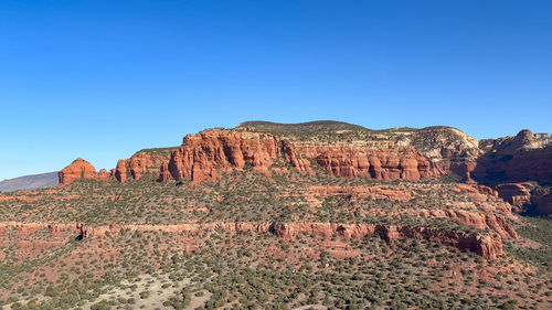 Rock formations on mountain against clear blue sky