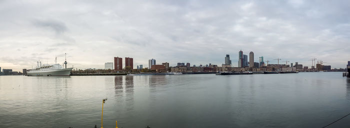 Sea by buildings against sky in city