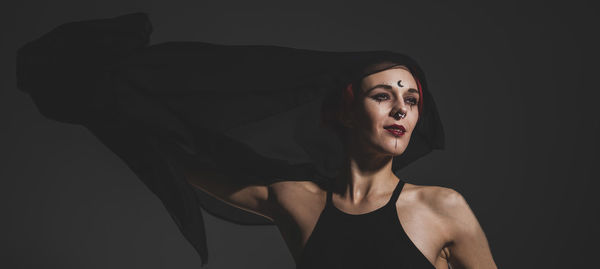 Woman looking away against black background