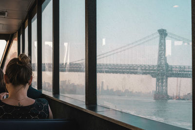 Rear view of woman looking through window