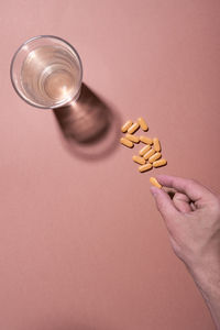 High angle view of hand holding wineglass against gray background