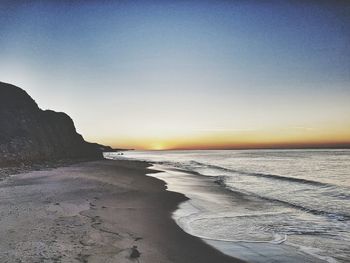 Scenic view of beach against sky during sunset