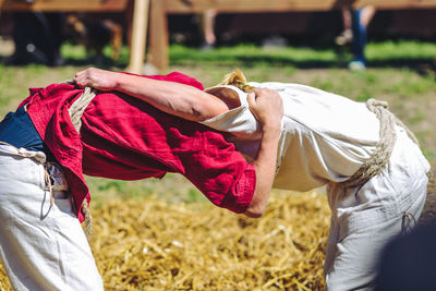 Side view of man and woman practicing martial arts on field