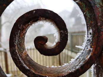 Close-up of rusty wheel against sky