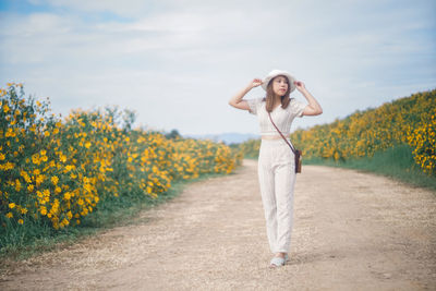 Portrait of woman standing on field against sky