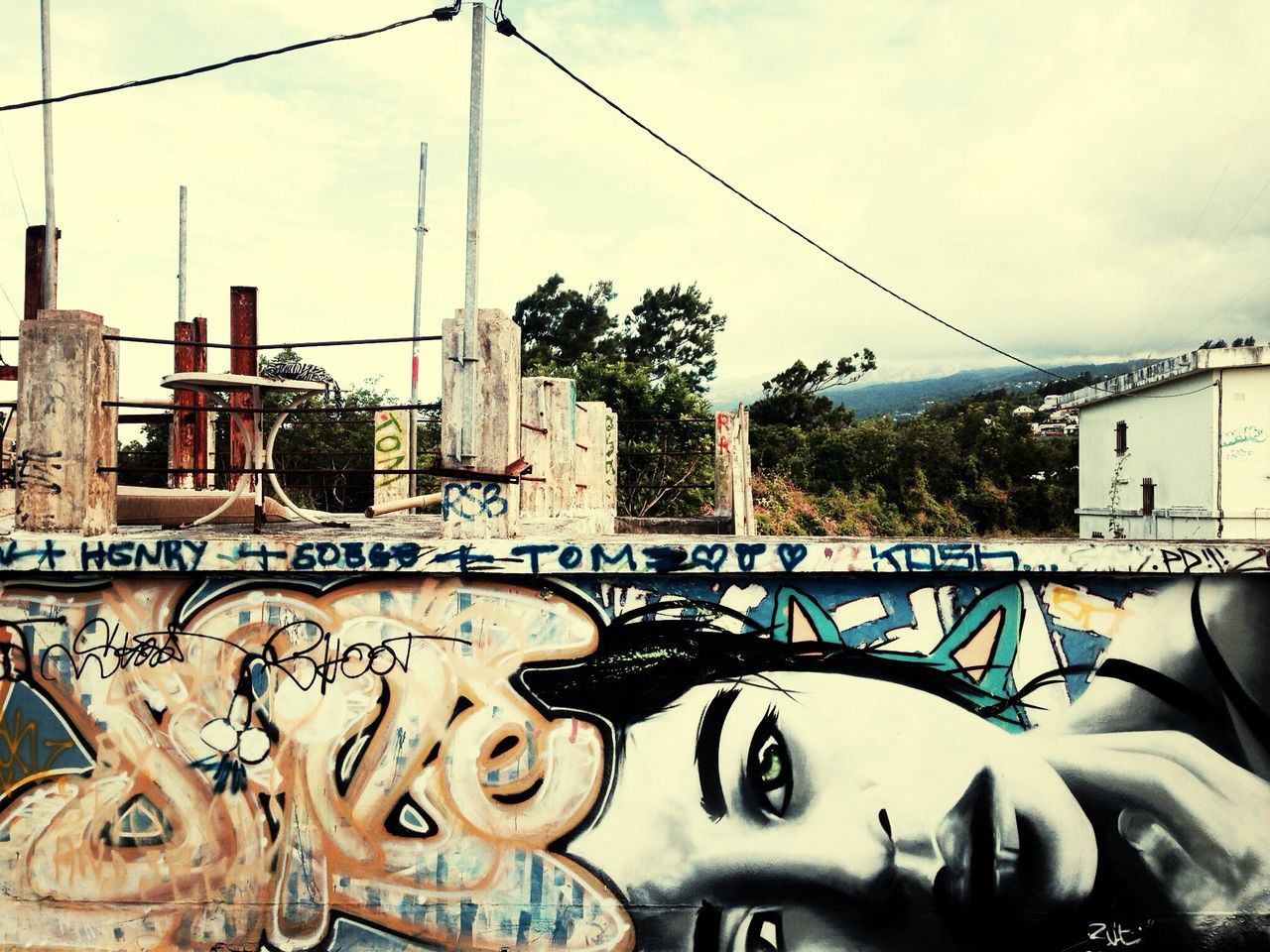 architecture, built structure, building exterior, sky, graffiti, railing, low angle view, cloud - sky, city, day, building, residential building, connection, art, outdoors, no people, residential structure, art and craft, cloud, creativity