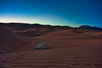 Scenic view of tent in sand dunes