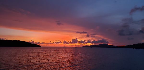 Scenic view of sea against dramatic sky during sunset