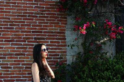 Woman in front of brick wall