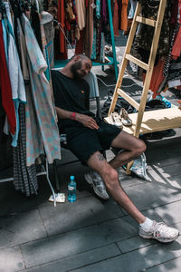 Full length of man sleeping at market stall