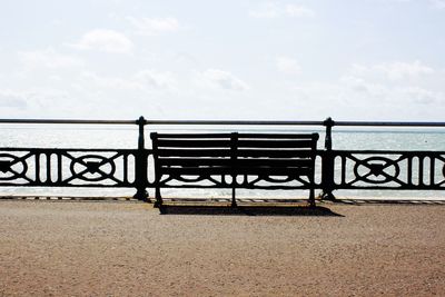 Empty bench overlooking calm sea