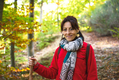 Portrait of smiling woman in forest during autumn