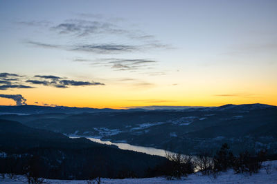 Scenic view of snowcapped mountains against sky during sunset