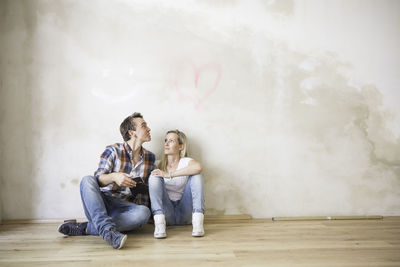 Portrait of couple sitting in empty room