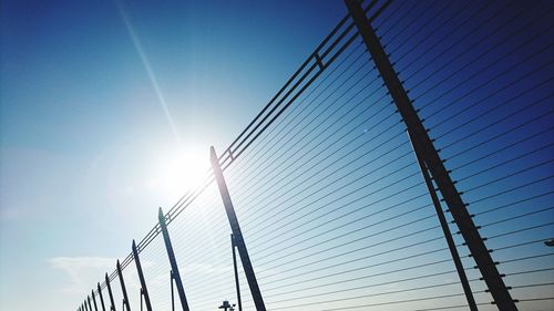 Low angle view of electricity pylon against blue sky