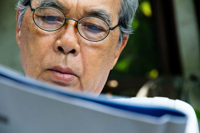 Close-up of senior man reading book