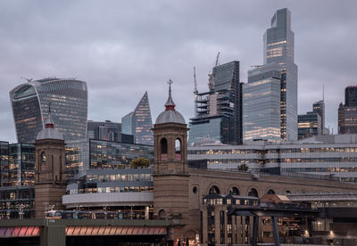 Illuminated buildings in city against sky