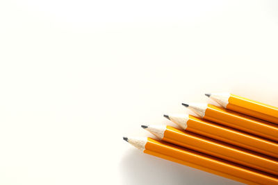 High angle view of colored pencils against white background