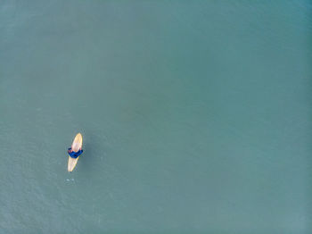 Aerial view of man on surfboard in sea