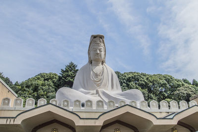 Low angle view of statue against building against sky