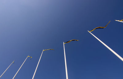 Low angle view of birds flying against blue sky