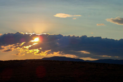 Scenic view of silhouette mountains against sky during sunset