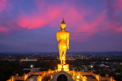 Statue of illuminated building against sky during sunset