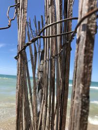 Close-up of wooden fence by sea against sky