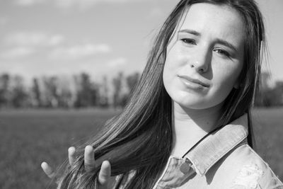 Close-up portrait of young woman against sky