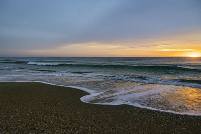 Scenic view of beach against sky during sunset