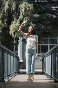 Full length of smiling standing on footbridge