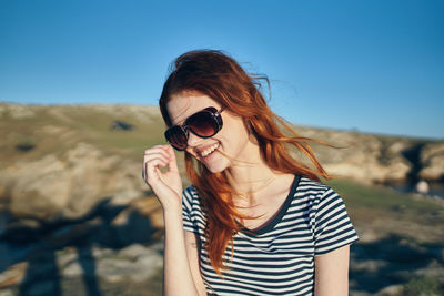 Young woman wearing sunglasses against sky