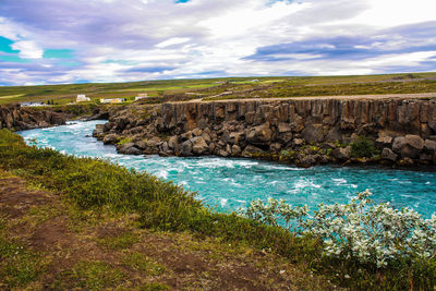 Scenic view of sea by cliff against sky