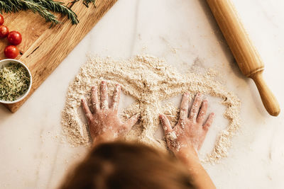 High angle view of child hand preparing food