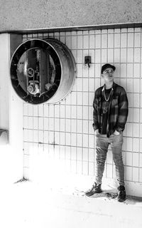 Portrait of a young man standing against wall