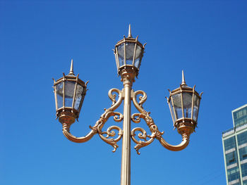 Low angle view of street light against blue sky