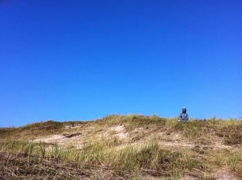 Scenic view of grassy field against clear sky