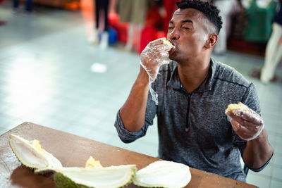 Man eating durian on table