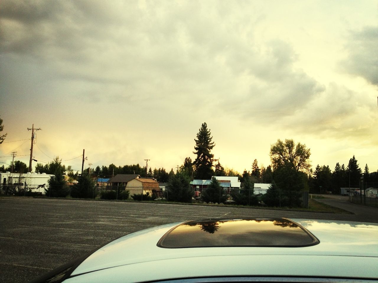 transportation, sky, mode of transport, car, cloud - sky, tree, land vehicle, road, cloud, street, sunset, cloudy, outdoors, building exterior, no people, nature, road marking, weather, dusk, architecture