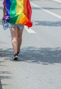 Low section of woman standing on road