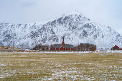 Church by on snowcapped mountain against clear sky