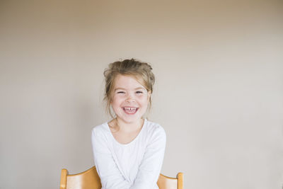 Portrait of a young girl sitting and smiling at the camera