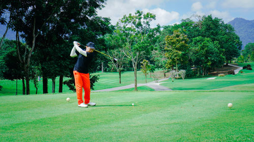 Male senior golfer swinging golf ball in a nature green grass fairway. professional golf player.