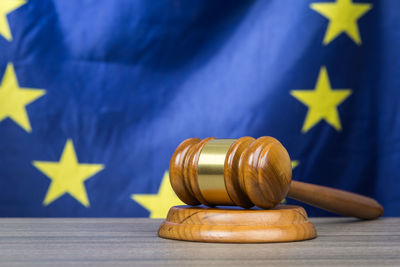 Close-up of gavel and hammer on table against national flag