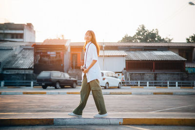 Full length of woman standing against built structure