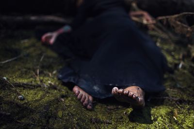 Low section of woman lying on field