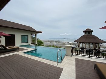 View of swimming pool by building against sky