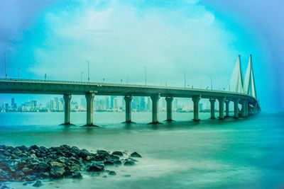 Bridge over sea against blue sky