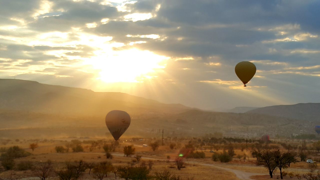 hot air balloon, flying, landscape, sky, sunset, beauty in nature, travel destinations, adventure, nature, scenics, transportation, outdoors, tree, vacations, no people, mountain, ballooning festival, day