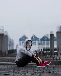 Man with umbrella against sky in city